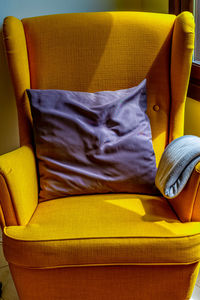 Close-up of yellow seat on bed