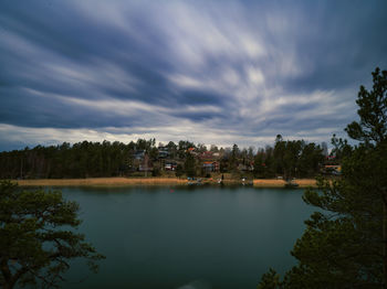 Scenic view of lake by trees against sky