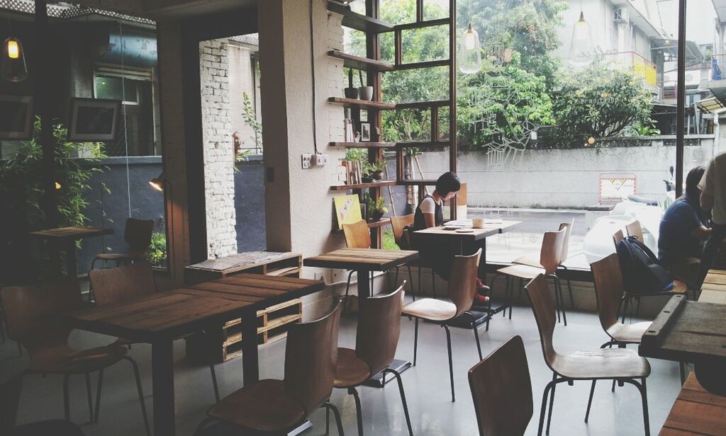 chair, table, indoors, absence, potted plant, empty, window, furniture, restaurant, built structure, architecture, house, seat, sunlight, place setting, plant, wood - material, arrangement, building exterior, day