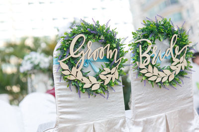 Close-up of groom and bride text decoration on chair during wedding celebration