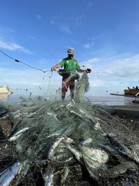 High angle view of man do net fishing on the beach