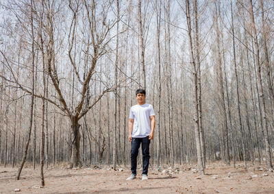 Full length portrait of man standing in forest