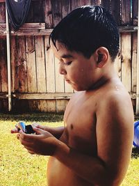 Shirtless boy standing at yard