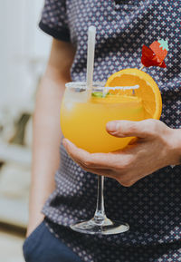 A young guy with a summer cocktail in his hands.