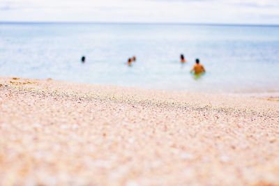 People on beach against sky