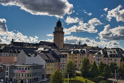 Buildings in city against cloudy sky