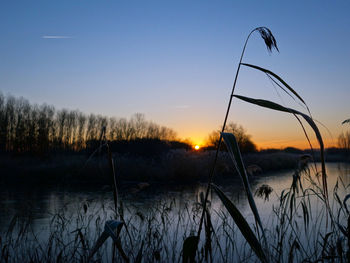Scenic view of lake against sky at sunset