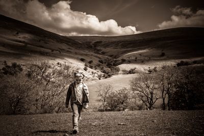 Full length of girl walking on field against sky