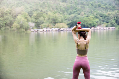 Rear view of woman standing by pink lake