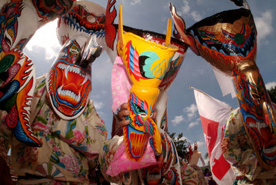 Low angle view of multi colored flags hanging against sky