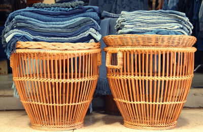 Stacked scarfs on wicker seats for sale in store