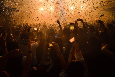 Group of people using mobile phones at music concert