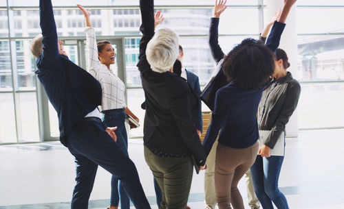 Business colleagues standing with hand raised