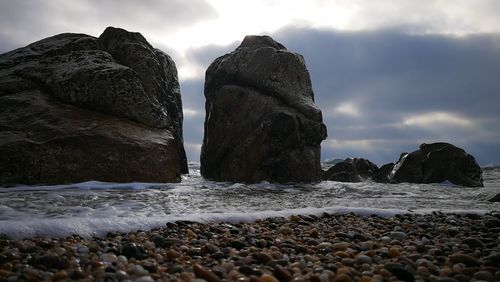 Surface level of rocks on beach against sky