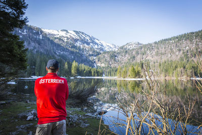 Man standing by lake against sky