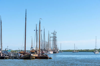 Sailboats in sea against clear blue sky