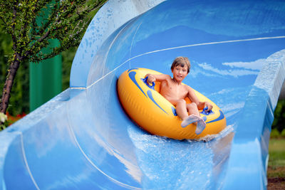 Portrait of cute boy sitting on inflatable ring