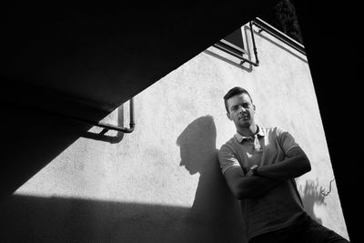 Portrait of young man standing against wall