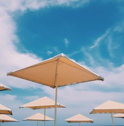 Low angle view of parasols against sky