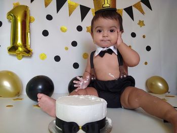 Portrait of cute boy sitting on table at home