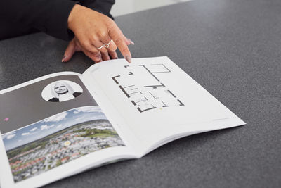 Female estate agent showing house brochure