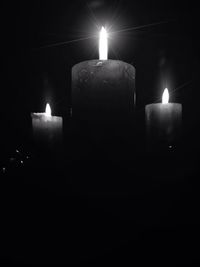 Lit candle in dark room