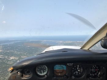 Close-up of airplane flying over sea against sky