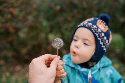 Close-up of girl blowing dandelion