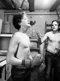 Shirtless men practicing boxing indoors