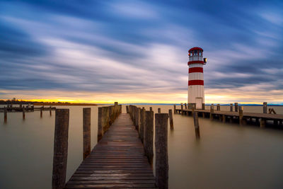 Pier over sea against sky during sunset