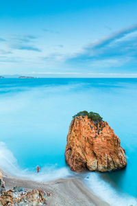 Rocks on sea shore against sky