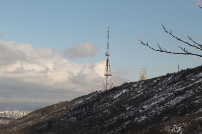 Communications tower against cloudy sky