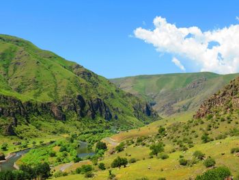 Scenic view of green landscape against blue sky