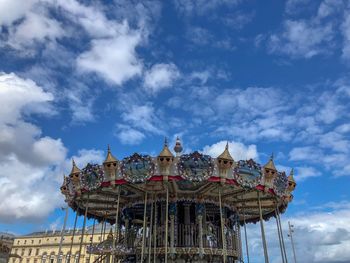 Low angle view of ferris wheel against buildings