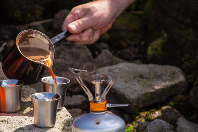 Midsection of man serving coffee in glass