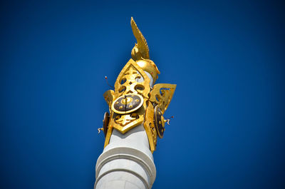 Low angle view of statue against blue sky