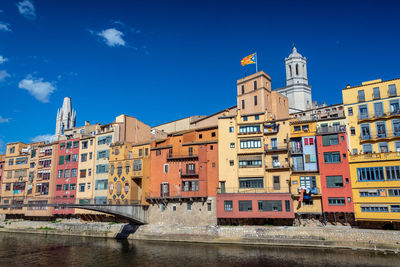 Arch bridge over river against buildings in city