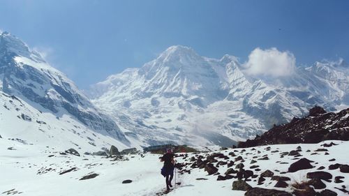 Person walking against snowcapped mountains