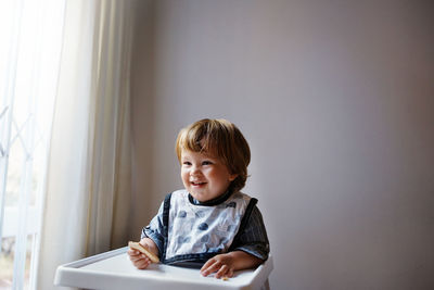 Portrait of cute boy sitting at home