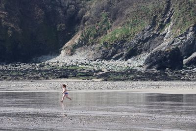 Full length of woman on rock in water