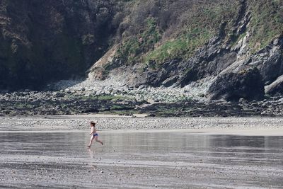 Shirtless boy running at beach