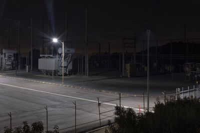 Light trails on road against sky at night