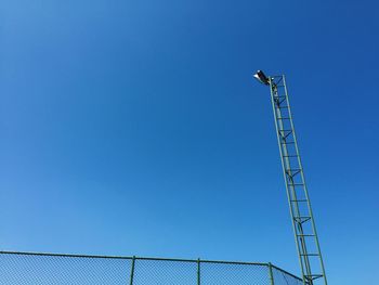 Low angle view of lighting equipment against clear blue sky on sunny day