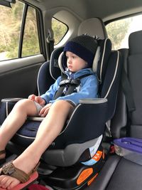 Full length of boy sitting in car
