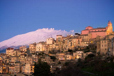 Buildings in city against blue sky