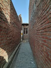 Narrow alley amidst buildings against sky