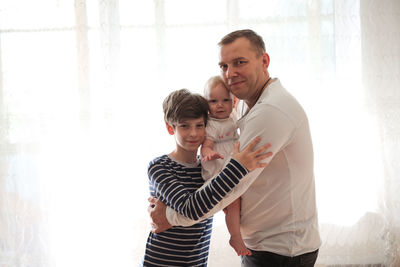 Adorable little daughter with her father and brother, involved father spending time with his toddler 