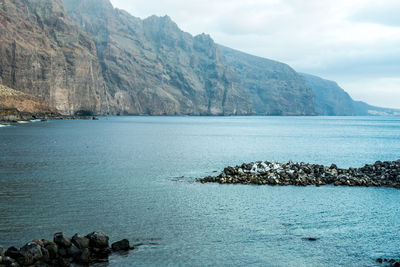 Scenic view of sea and mountains against sky