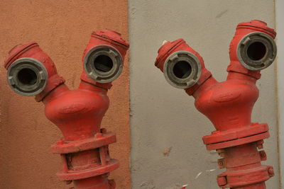 Close-up of fire hydrants against wall