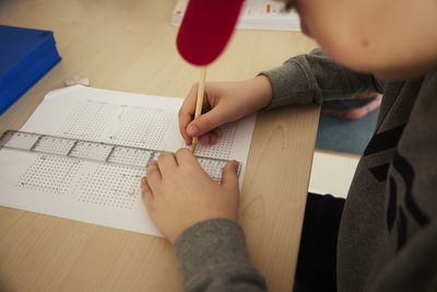 Boy using ruler and pencil at school